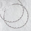 Full view of handmade sterling silver wedding crowns with pink crystals and white ribbon on a white textured background.