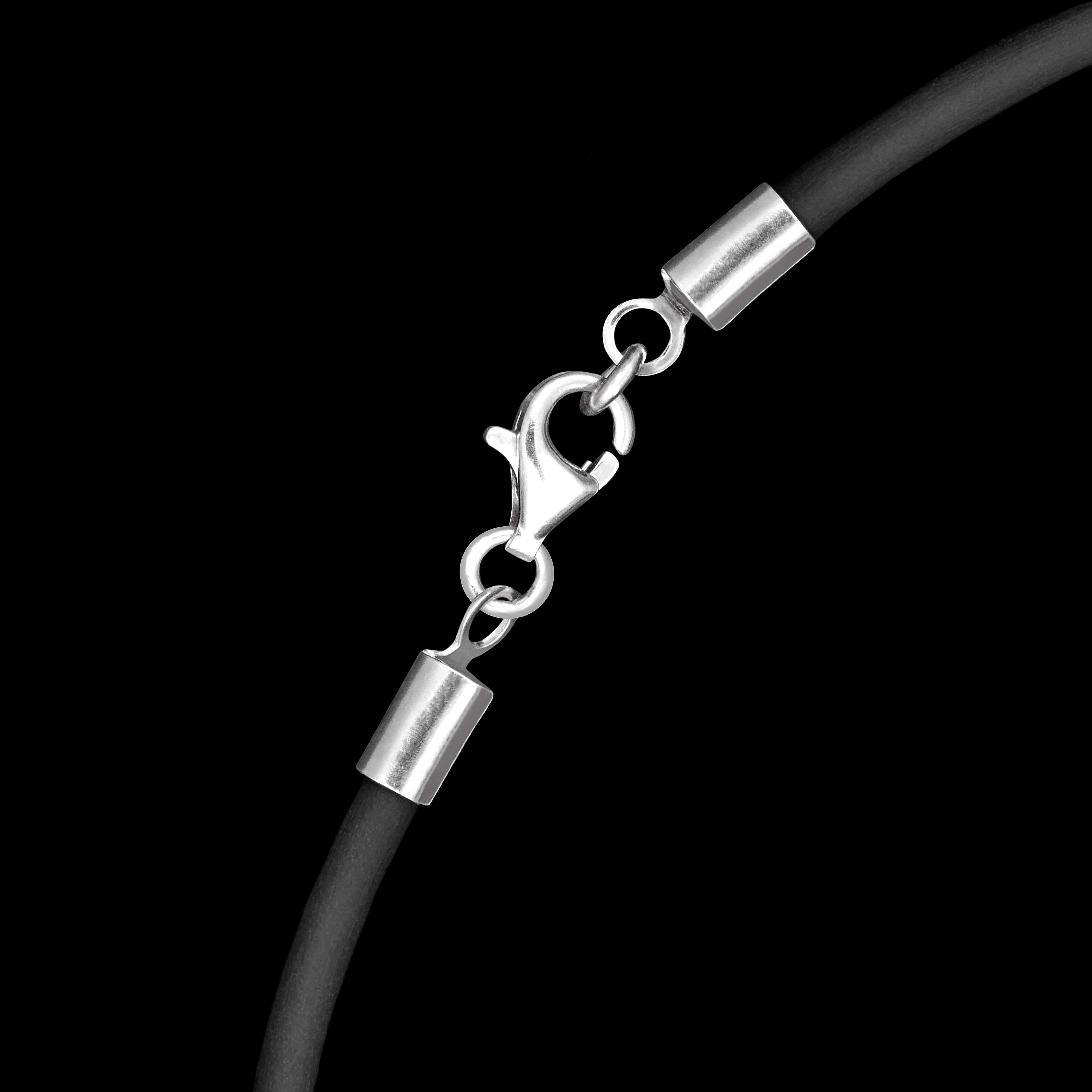 Close-up of a black rubber cord with silver clasp on a black background
