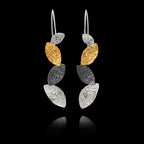 Pair of earrings with hammered gold and silver leaf-like designs on a black background