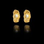 Front view of organic-shaped gold stud earrings with a wavy shell-like texture and a central white pearl.