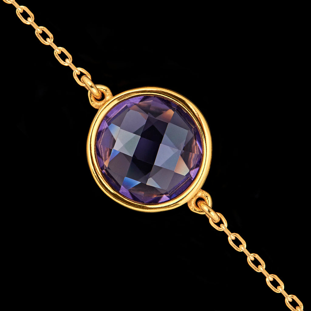 Close-up detail of the round faceted synthetic amethyst gemstone set in a gold-plated bezel.