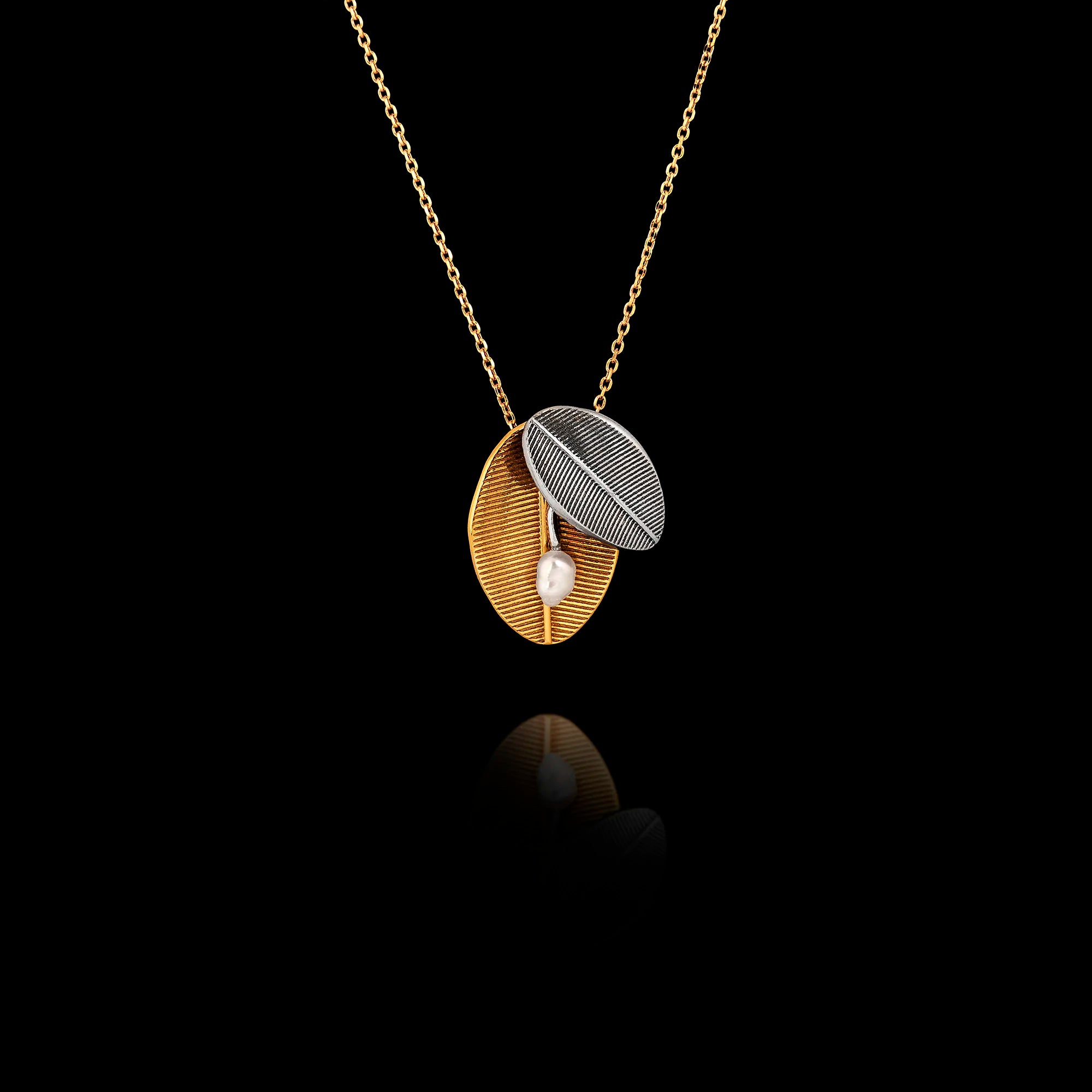 Two-tone 925 sterling silver necklace featuring a gold-plated olive leaf and a silver leaf with a central pearl accent on a gold chain.