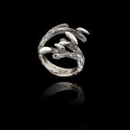 Silver ring with olive leaf design on a black background