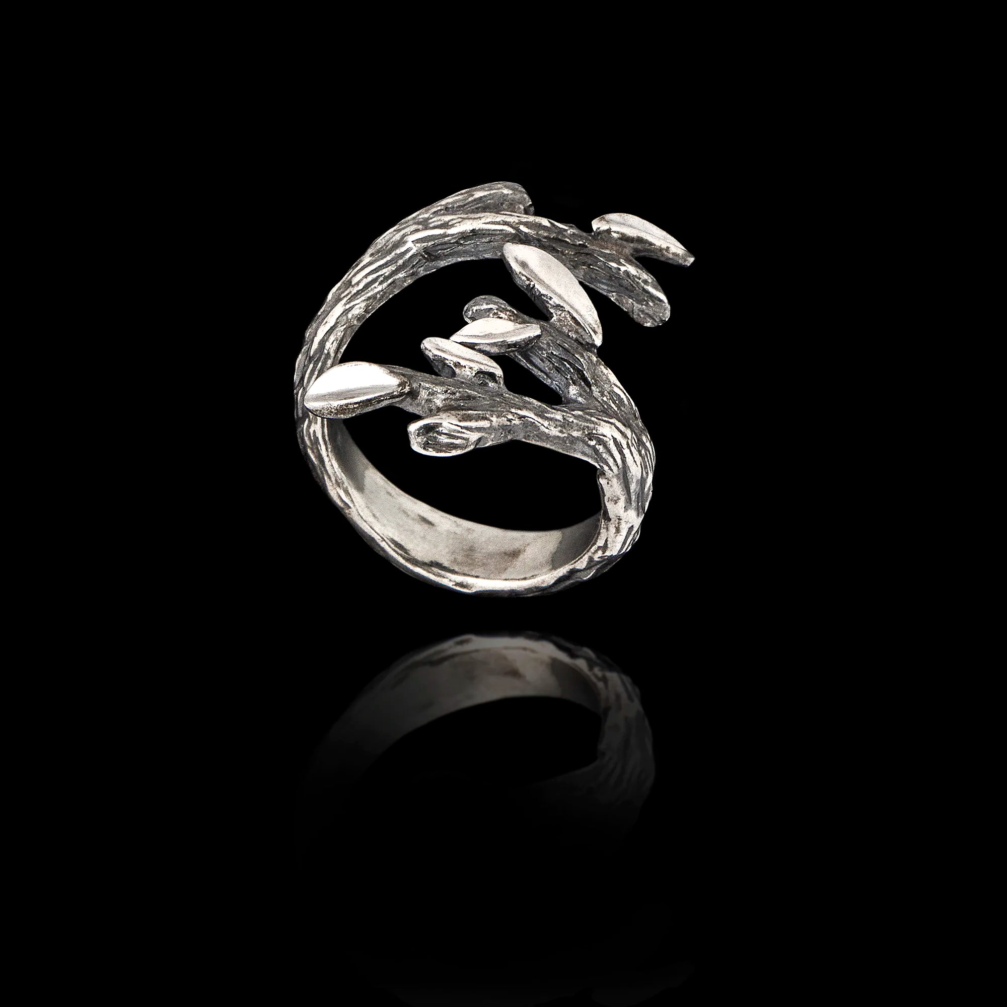 Silver ring with olive leaf design on a black background