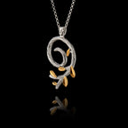 Perspective view of a silver spiral olive branch pendant on a chain, featuring a rhodium-plated stem and gold-plated leaves.