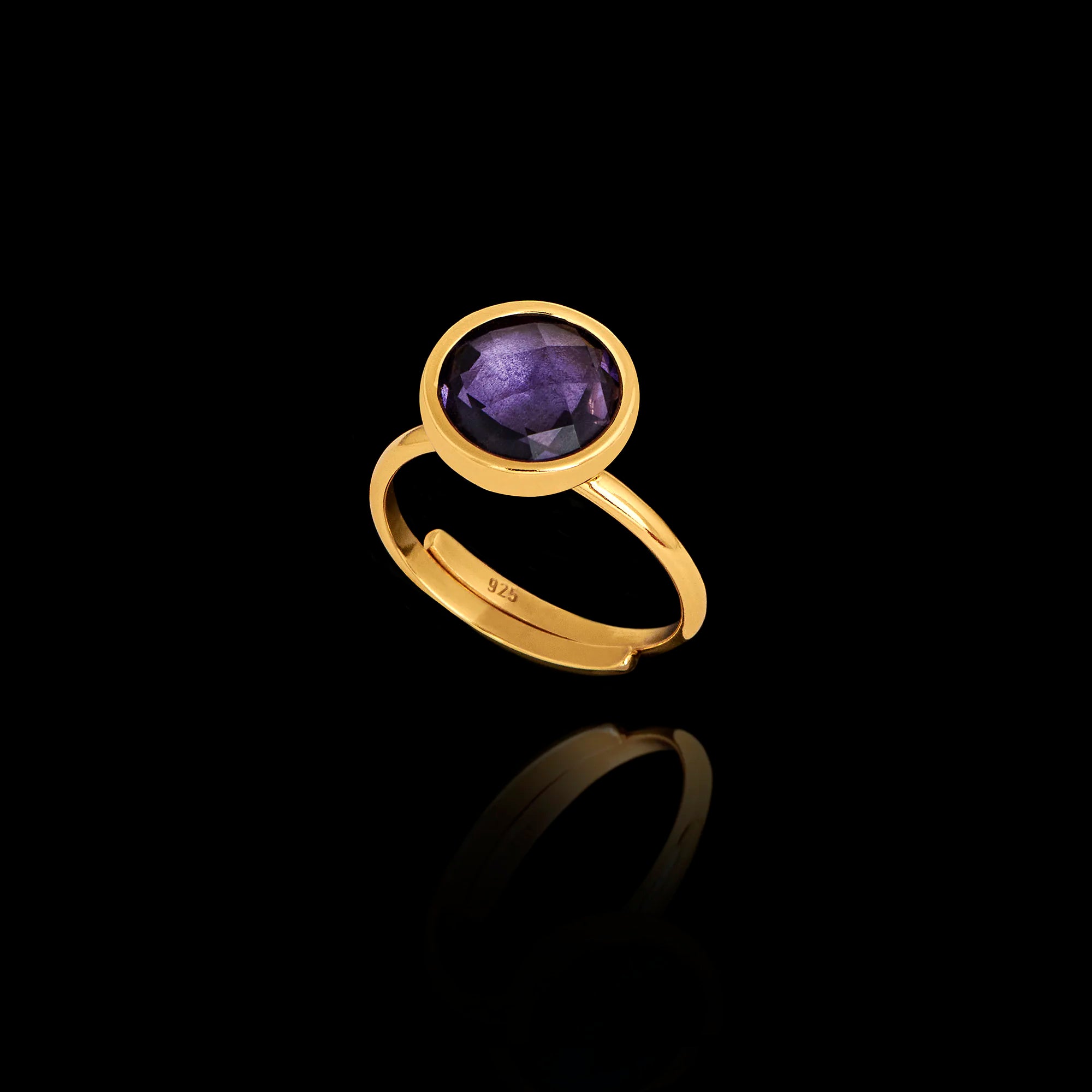 Gold ring featuring a round faceted amethyst gemstone in a bezel setting.