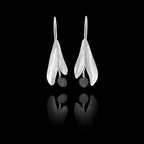 Front view of silver drop earrings featuring two matte-finish leaves with a dark, textured round gemstone at the bottom.