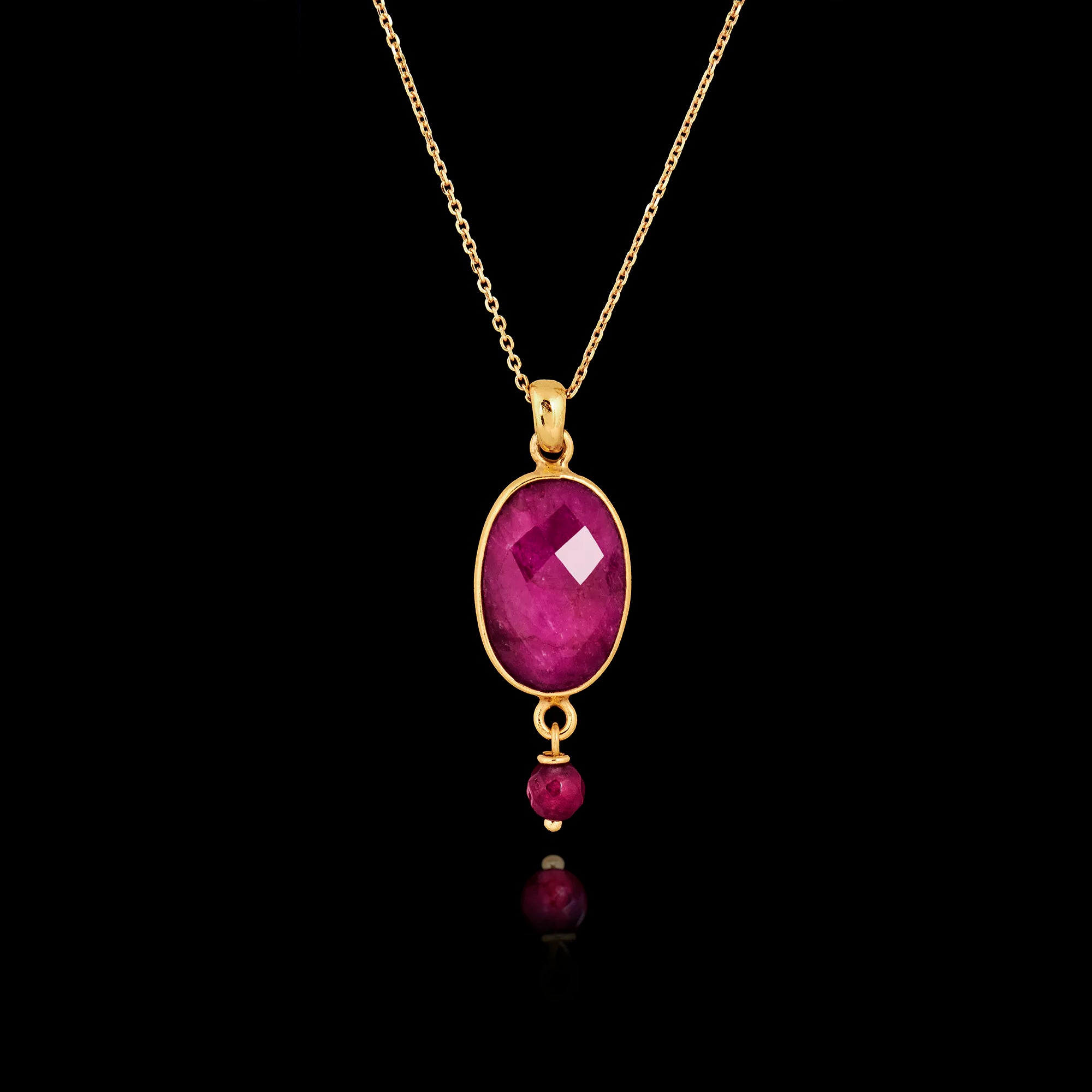 Gold plated 925 sterling silver pendant necklace featuring a large oval ruby gemstone with a small ruby bead dangle on an adjustable chain.