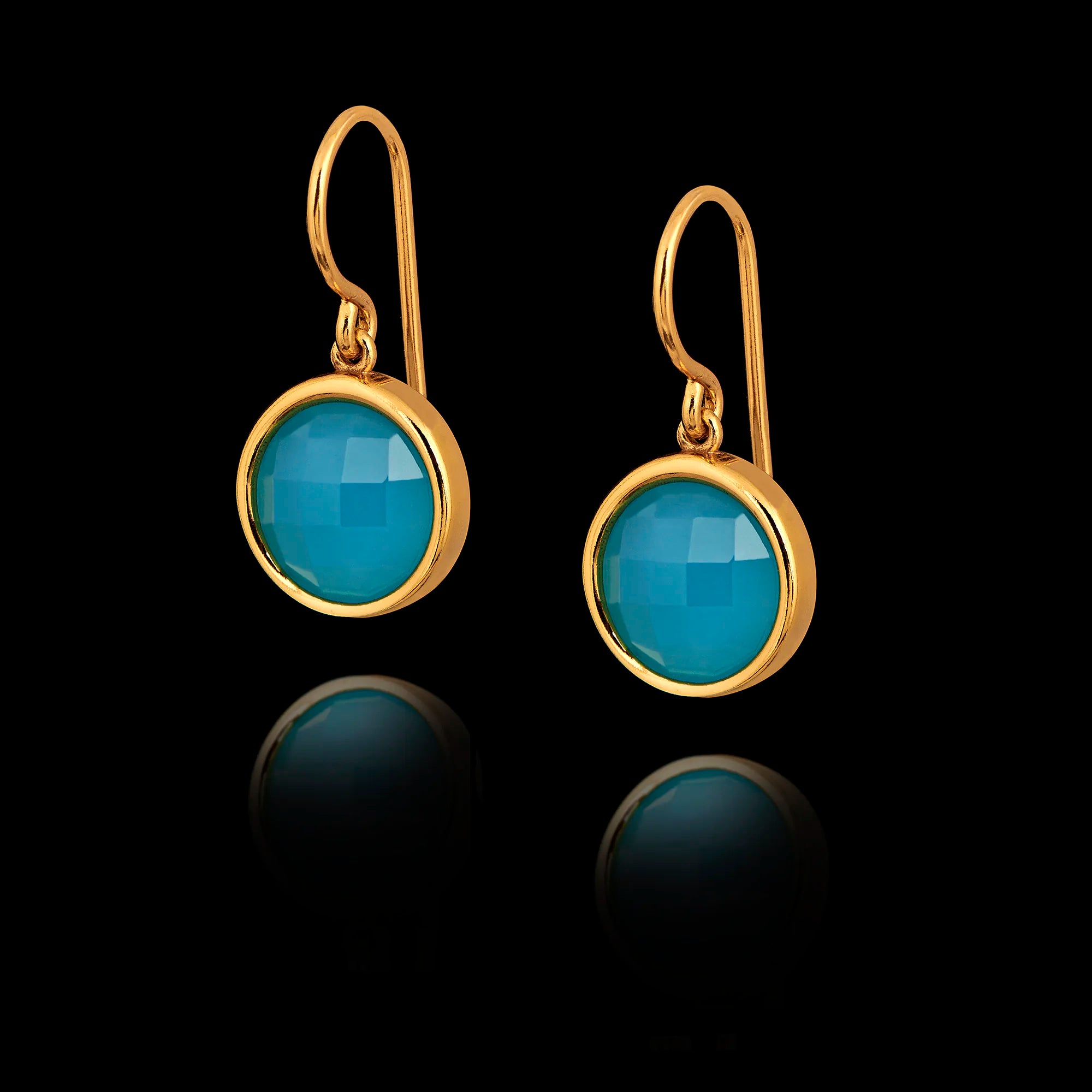 Gold earrings with turquoise gemstones on a black background Main image