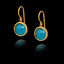 Gold earrings with turquoise gemstones on a black background