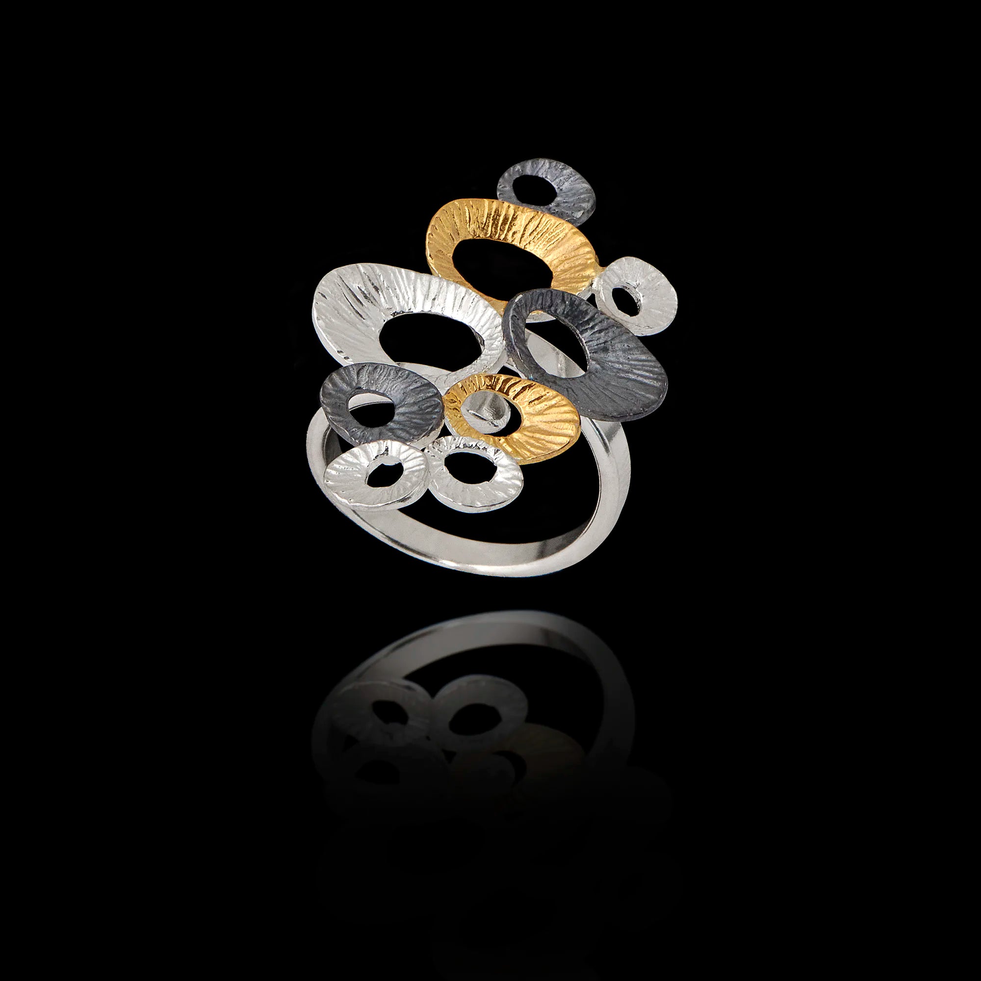 A clustered statement ring featuring multiple limpet shells in silver, gold, and oxidized finishes Main image