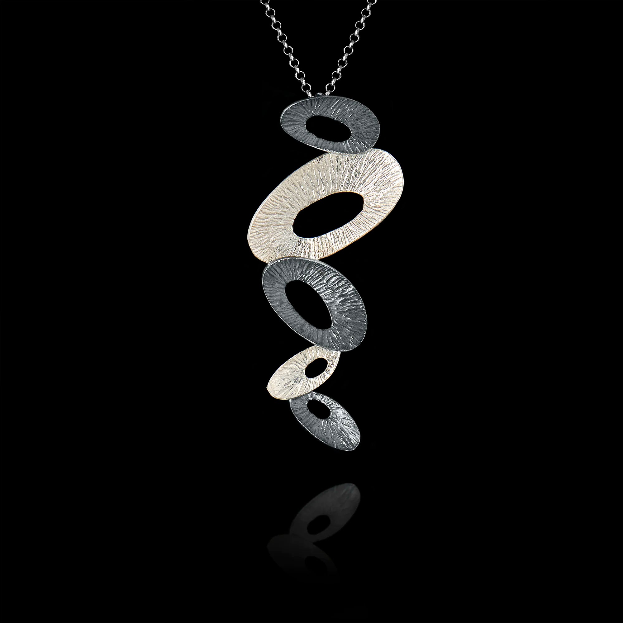 Silver pendant necklace on a black background