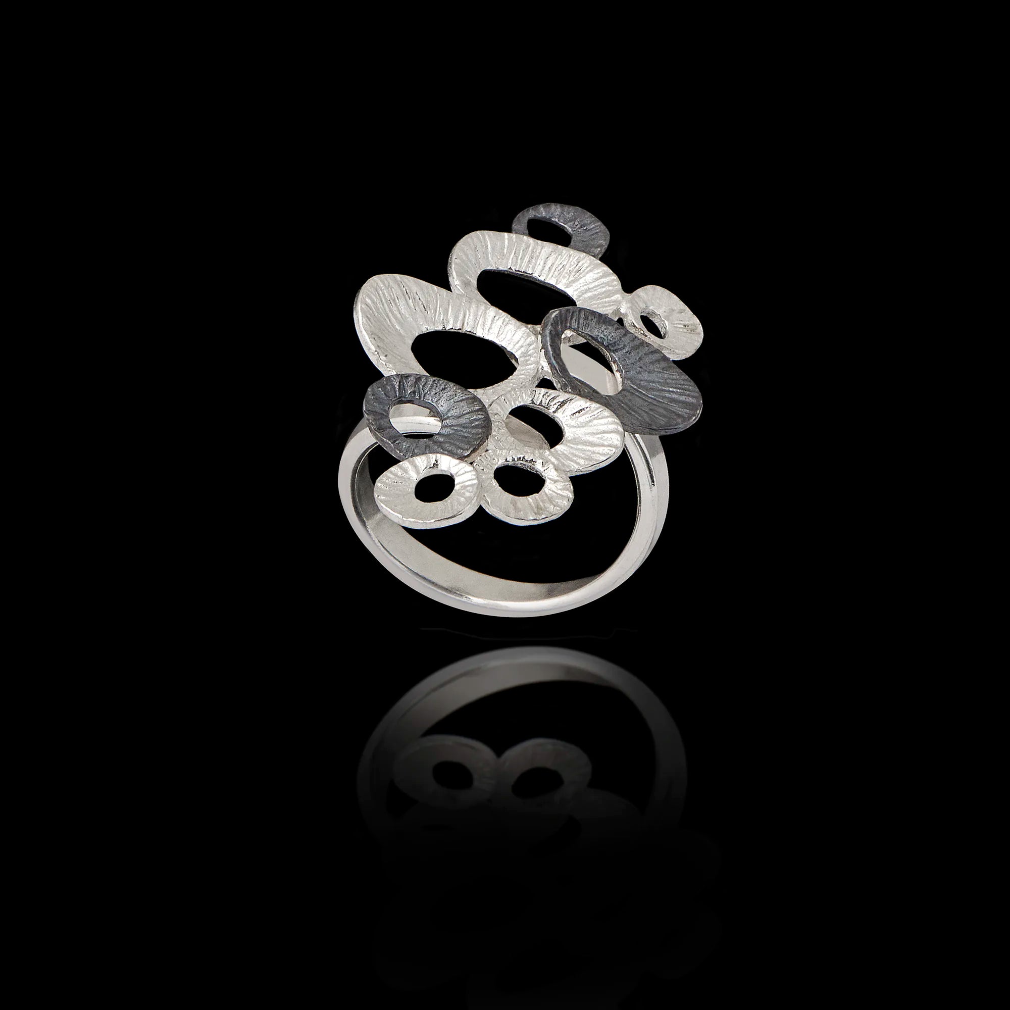 A clustered statement ring featuring multiple limpet shells in silver and oxidized finishes