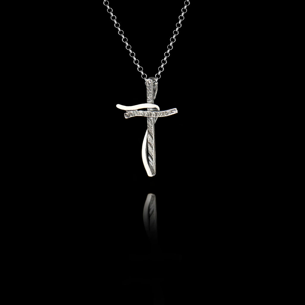Silver cross pendant on a chain against a black background