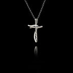 Silver cross pendant on a chain against a black background