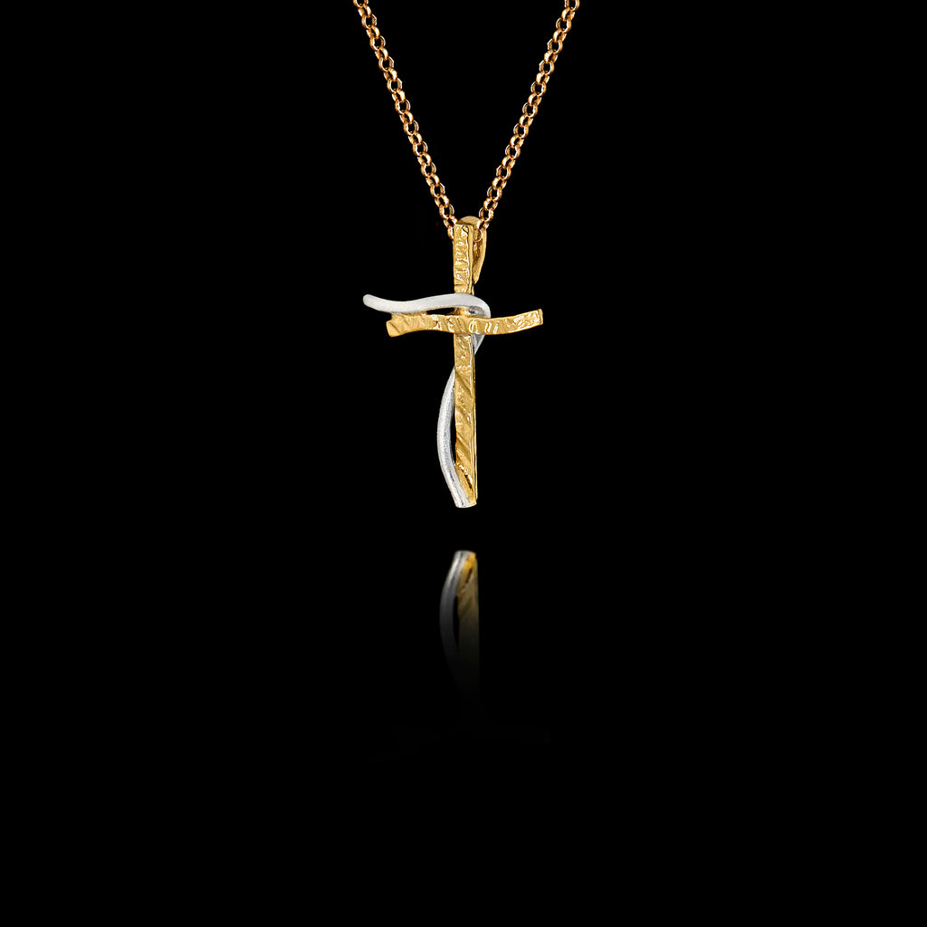 Side angle view of a handcrafted 925 sterling silver two-tone cross pendant showing the interplay between the gold-plated textured cross and the rhodium-plated curved accent, on a gold chain.