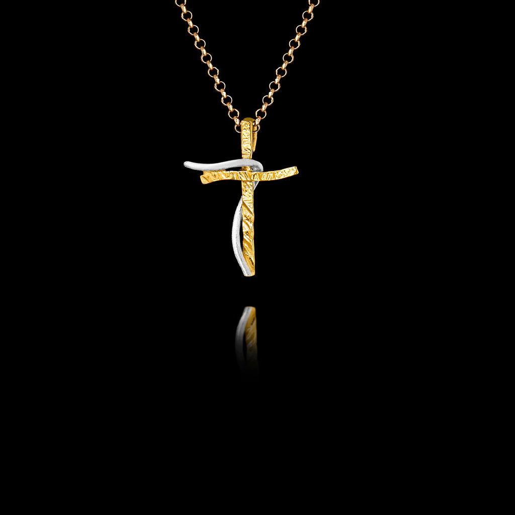 A handcrafted 925 sterling silver two-tone cross pendant featuring a textured gold-plated cross with a smooth rhodium-plated ribbon accent, hanging on a gold chain against a black background.