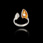 Front view of an adjustable silver ring featuring a textured shell and an open mussel shell with a gold interior and a pearl.
