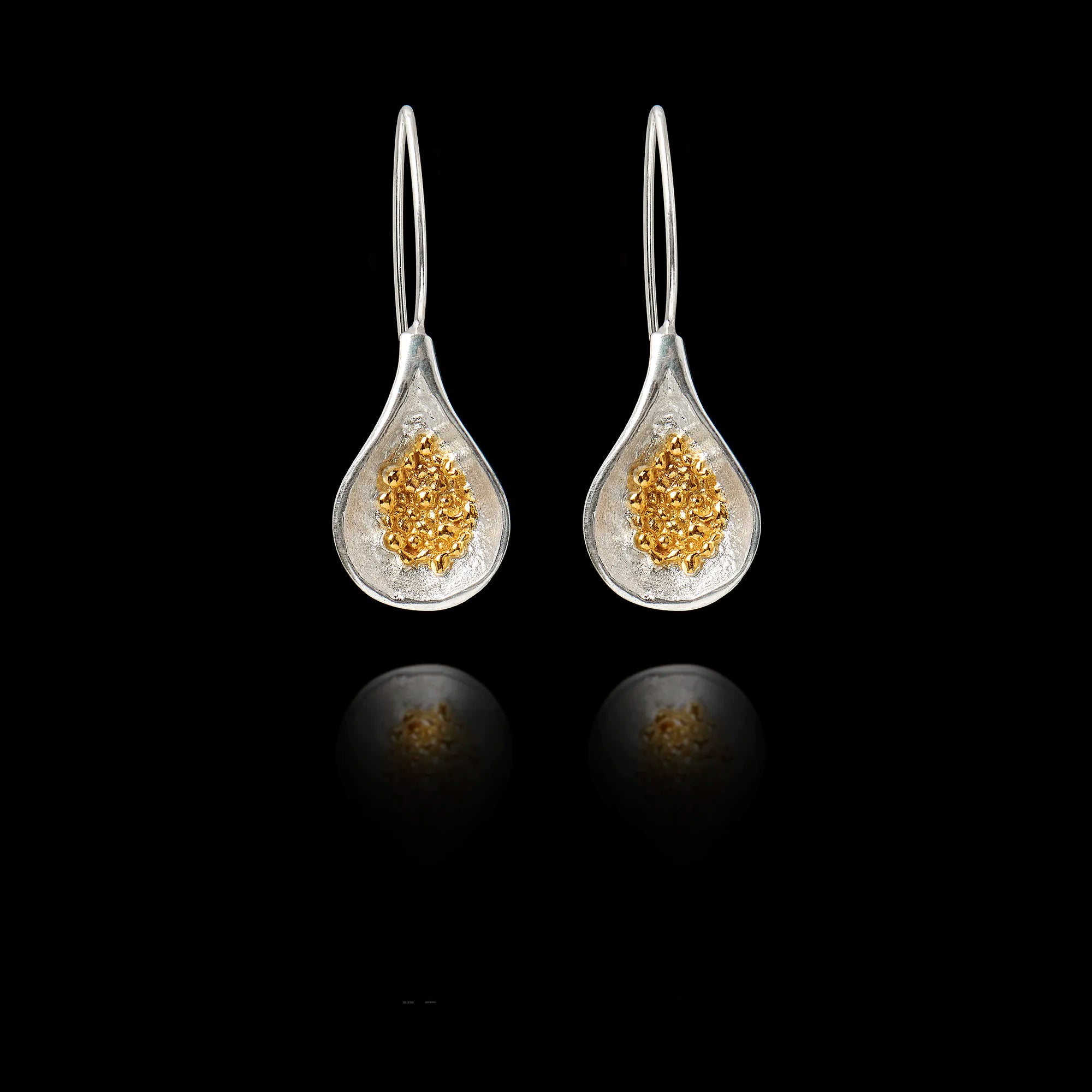 Front view of silver teardrop earrings with  gold cluster of fig seeds inside.