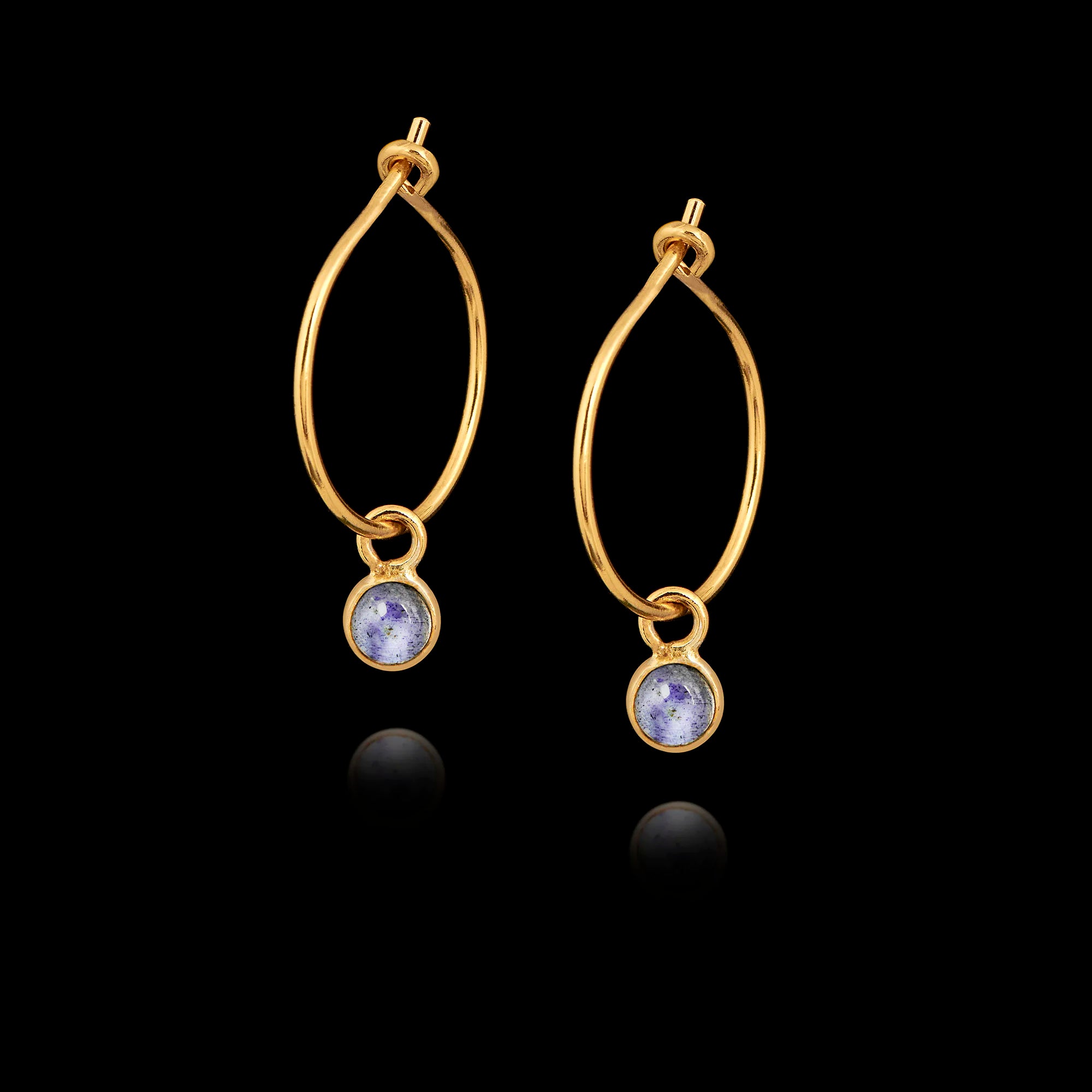 Gold hoop earrings with gemstones on a black background