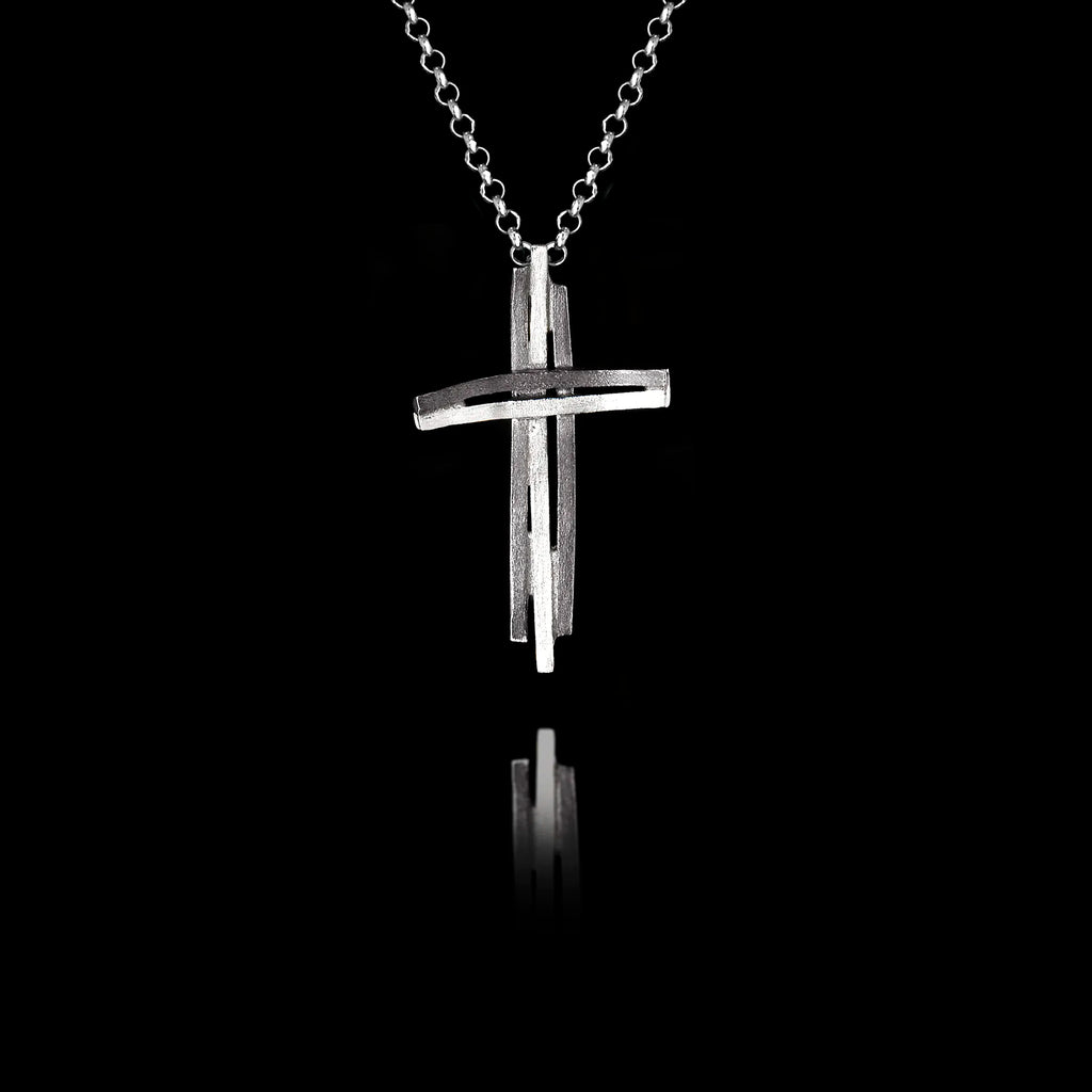 Handcrafted 925 sterling silver modern cross pendant featuring a sculptural double-bar design with oxidised and rhodium-plated finish, on a silver chain against a black background.