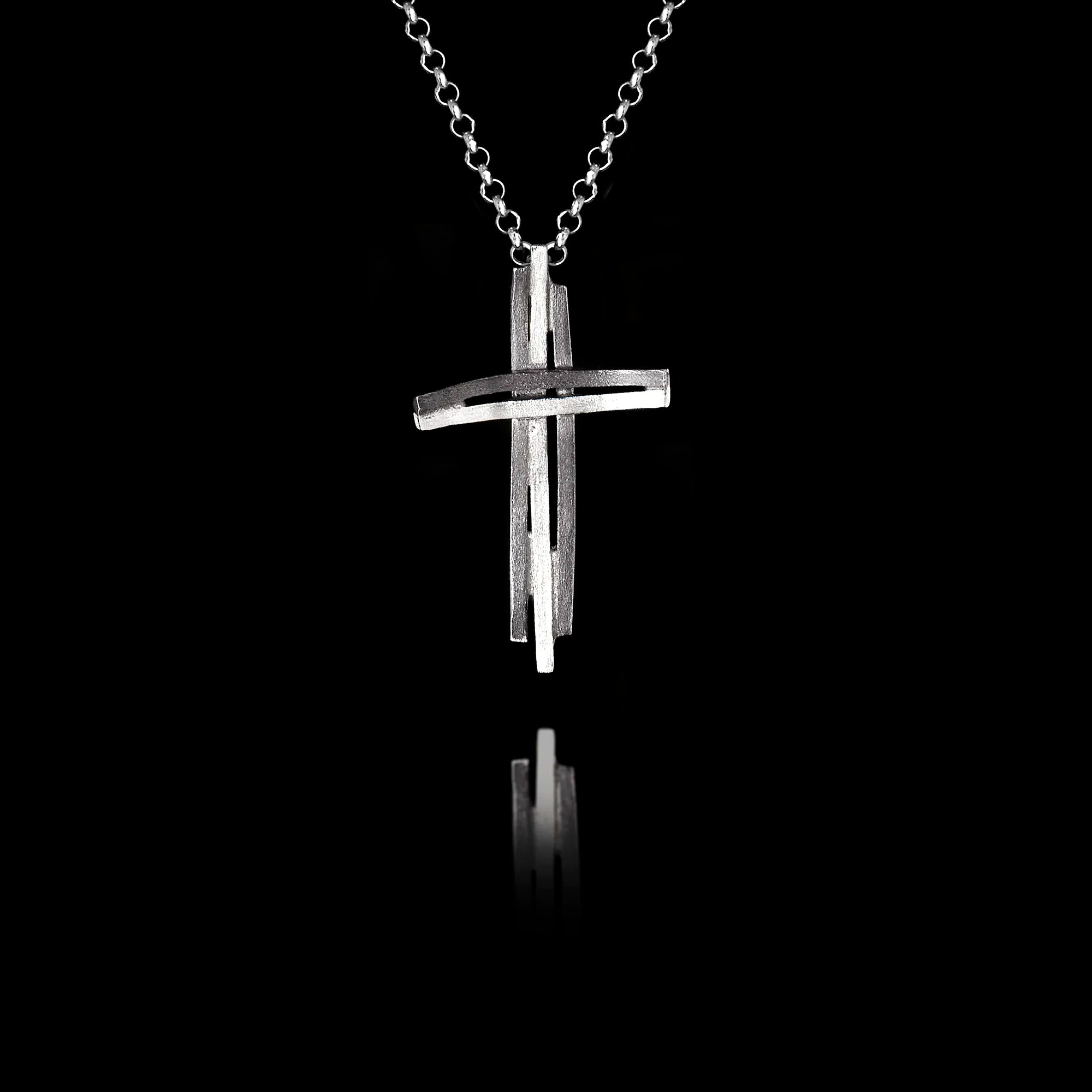 Handcrafted 925 sterling silver modern cross pendant featuring a sculptural double-bar design with oxidised and rhodium-plated finish, on a silver chain against a black background. Main image