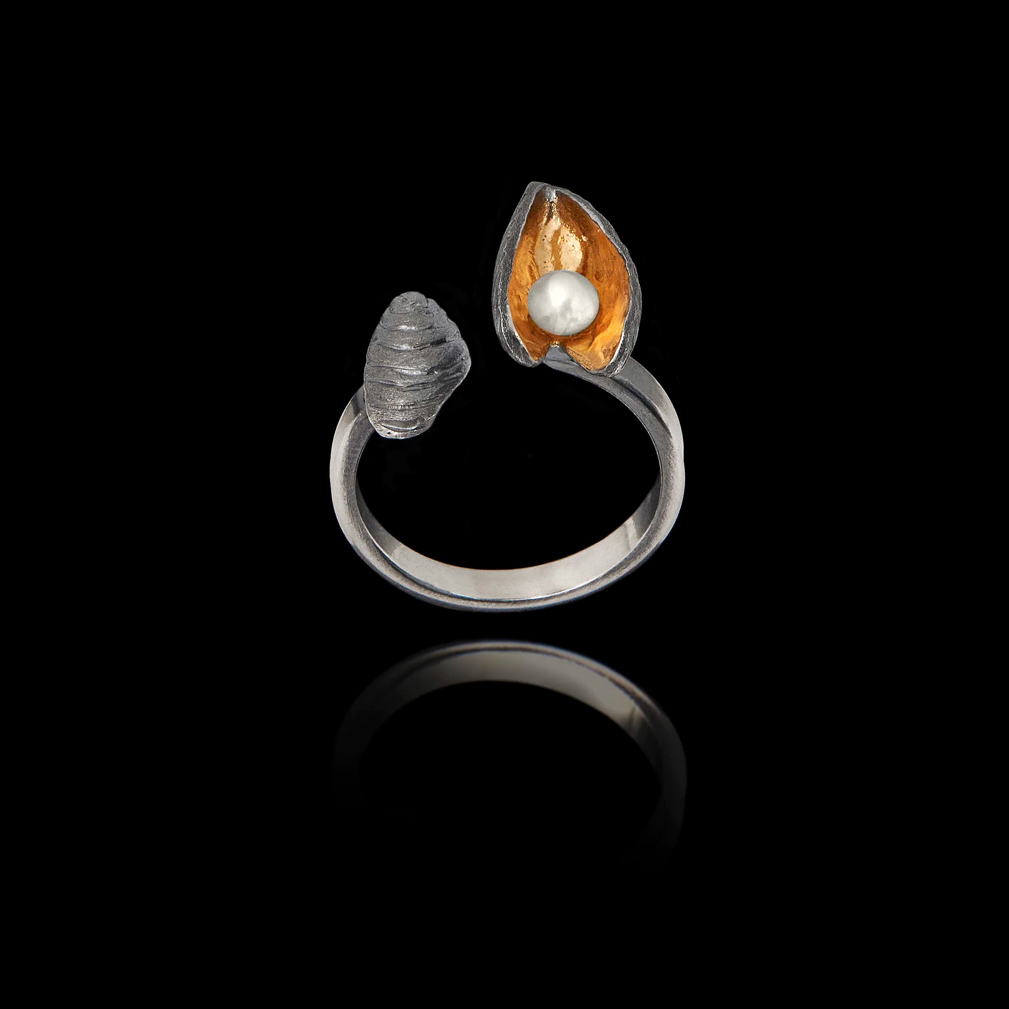 Front view of an adjustable 925 sterling silver ring with a dark oxidized finish, featuring an open mussel shell with a gold-plated interior and a pearl.