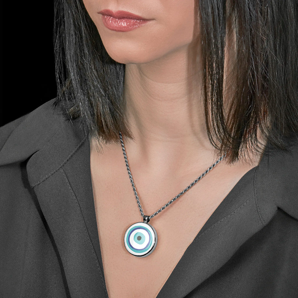 Woman wearing a necklace with a pendant featuring the traditional blue, turquoise, and white Evil Eye (Mati) symbol.