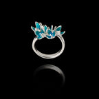 Silver ring with blue floral design on a black background