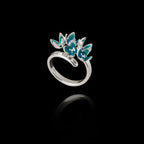 Angled view of an adjustable 925 sterling silver ring featuring a cluster of five flowers with bright turquoise enamel petals.