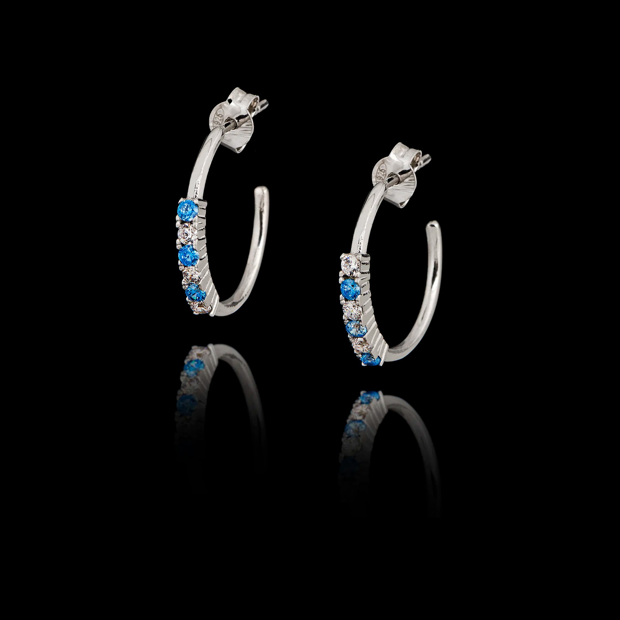 Silver hoop earrings with sapphire CZ and zircon gemstones on a black background