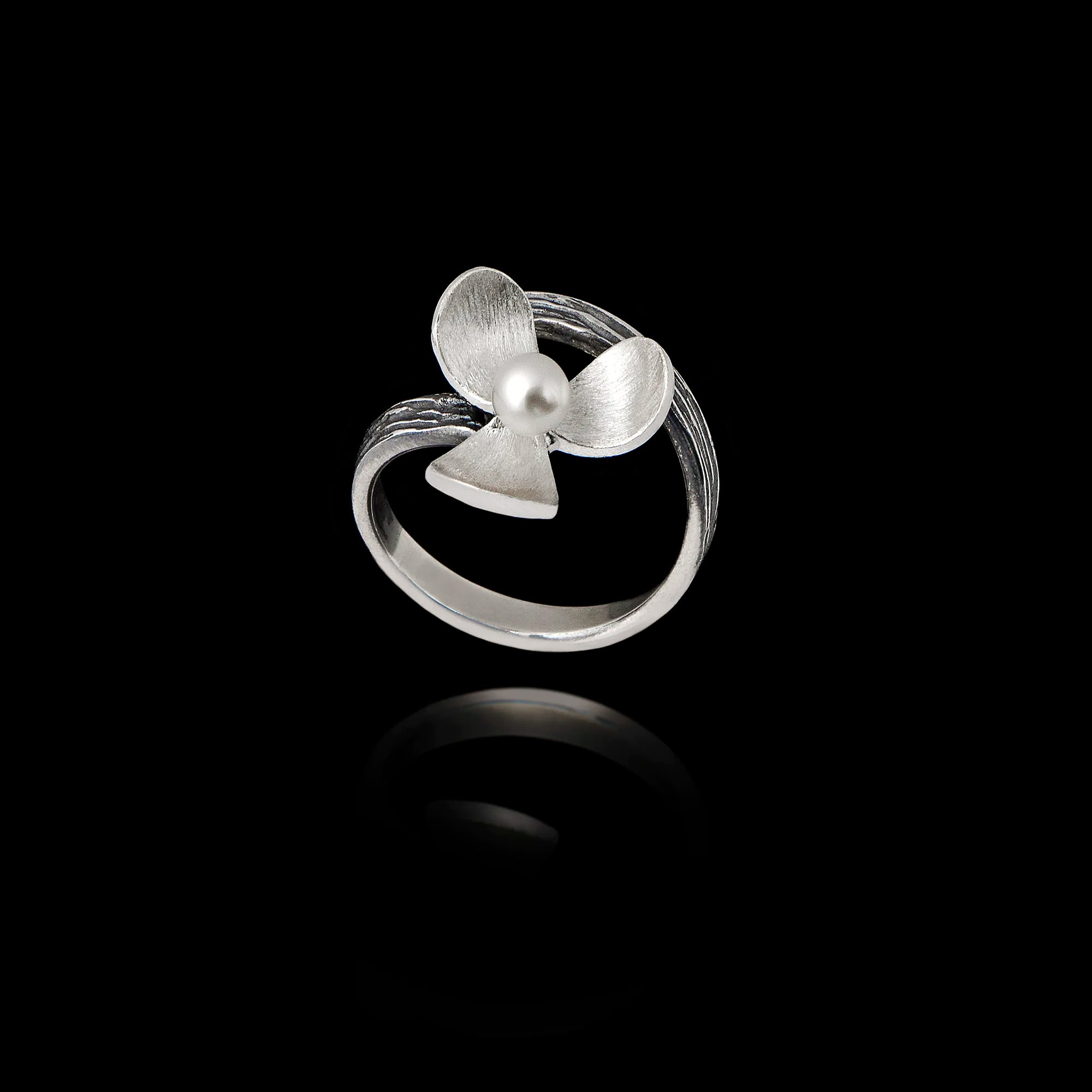 Top view of an adjustable silver ring designed as a flower with textured petals and a pearl in the center.
