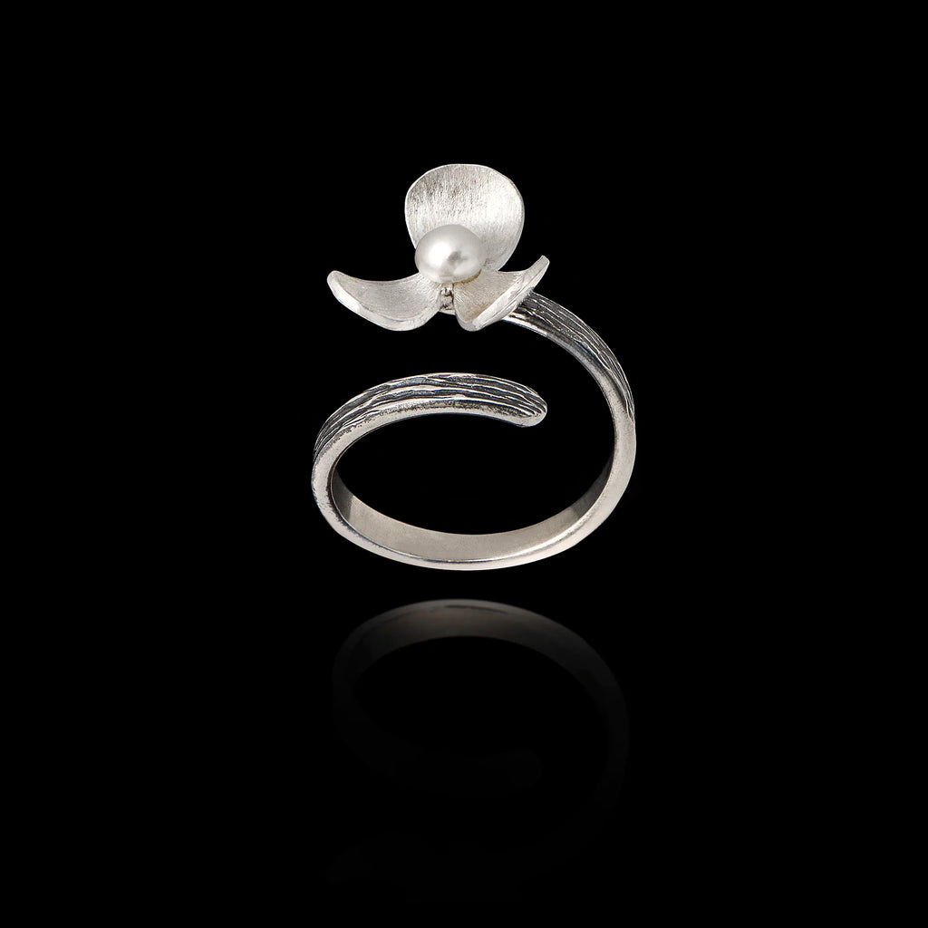 Perspective view of an adjustable silver ring designed as a flower with textured petals and a pearl in the center.
