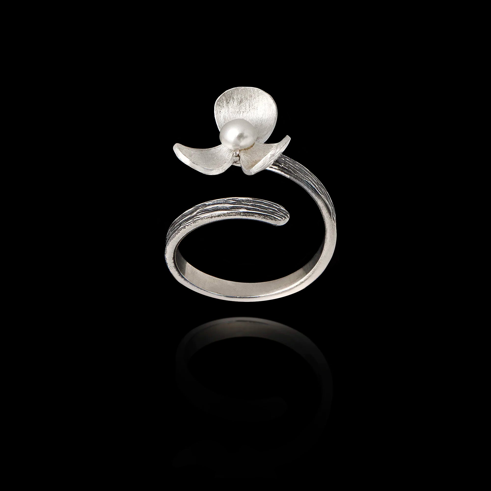 Perspective view of an adjustable silver ring designed as a flower with textured petals and a pearl in the center.