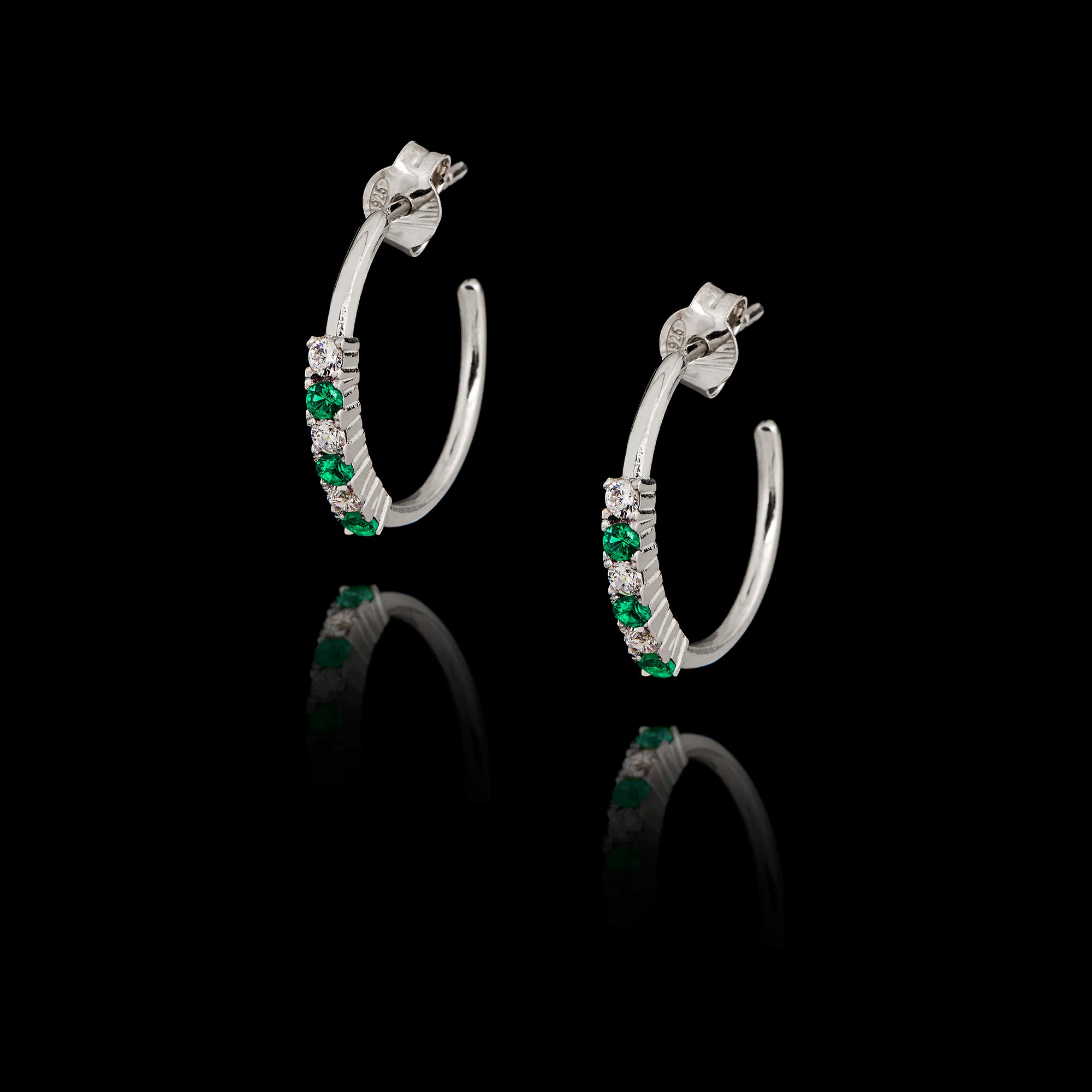 Silver hoop earrings with emerald cz and zircon gemstones on a black background Main image