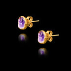 Angled side view of gold stud earrings featuring circular purple amethyst druzy stones.