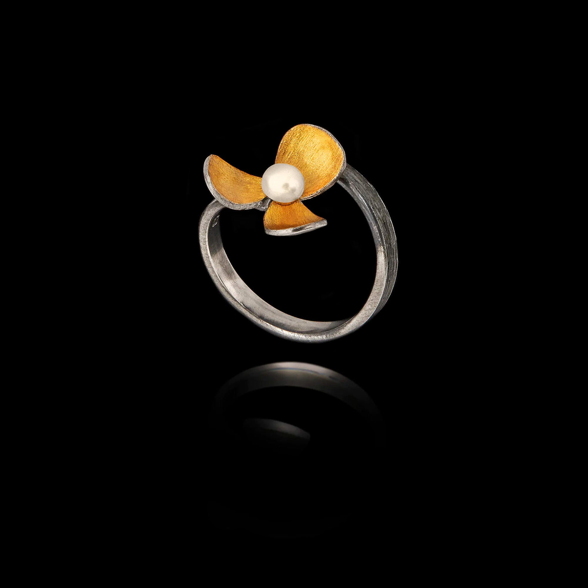 Side view showing the adjustable band and the detailed, textured petals of the oxidized floral ring.