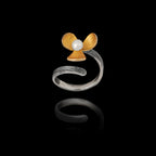 Perspective view of an adjustable silver ring featuring an oxidized flower with a gold-plated center and a pearl.