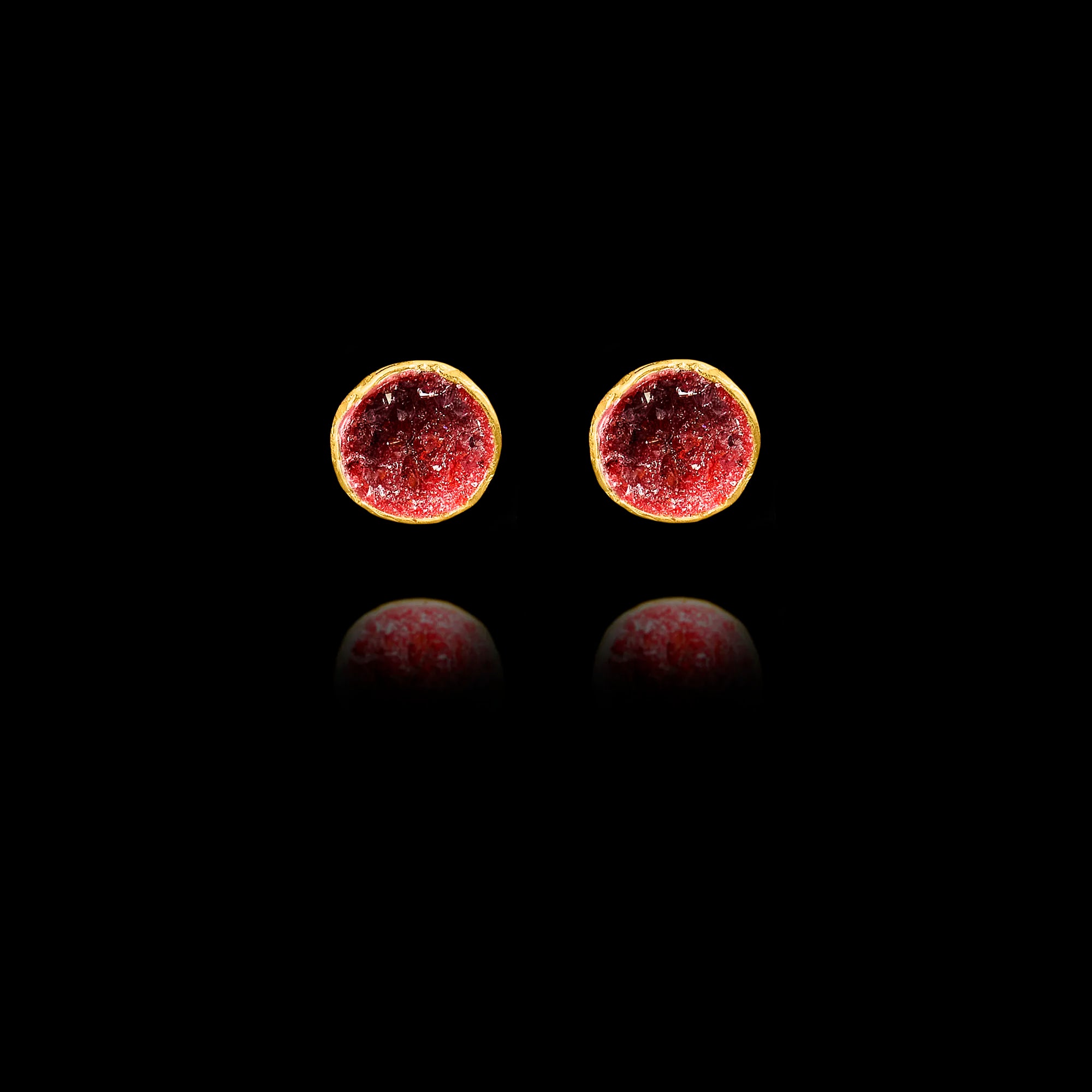 Front view of gold stud earrings featuring circular crimson garnet druzy stones