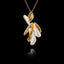 Handcrafted 925 sterling silver shell cluster pendant with rhodium-plated exterior and gold-plated interior shell forms cradling a freshwater pearl, hanging on a gold chain against a black background.