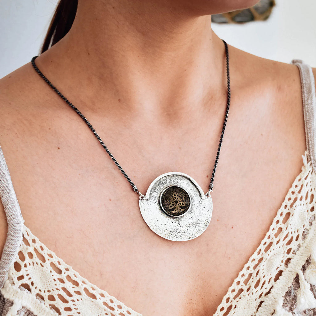 Necklace with a round pendant worn by a person