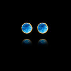 Front view of gold stud earrings featuring circular blue agate druzy stones.