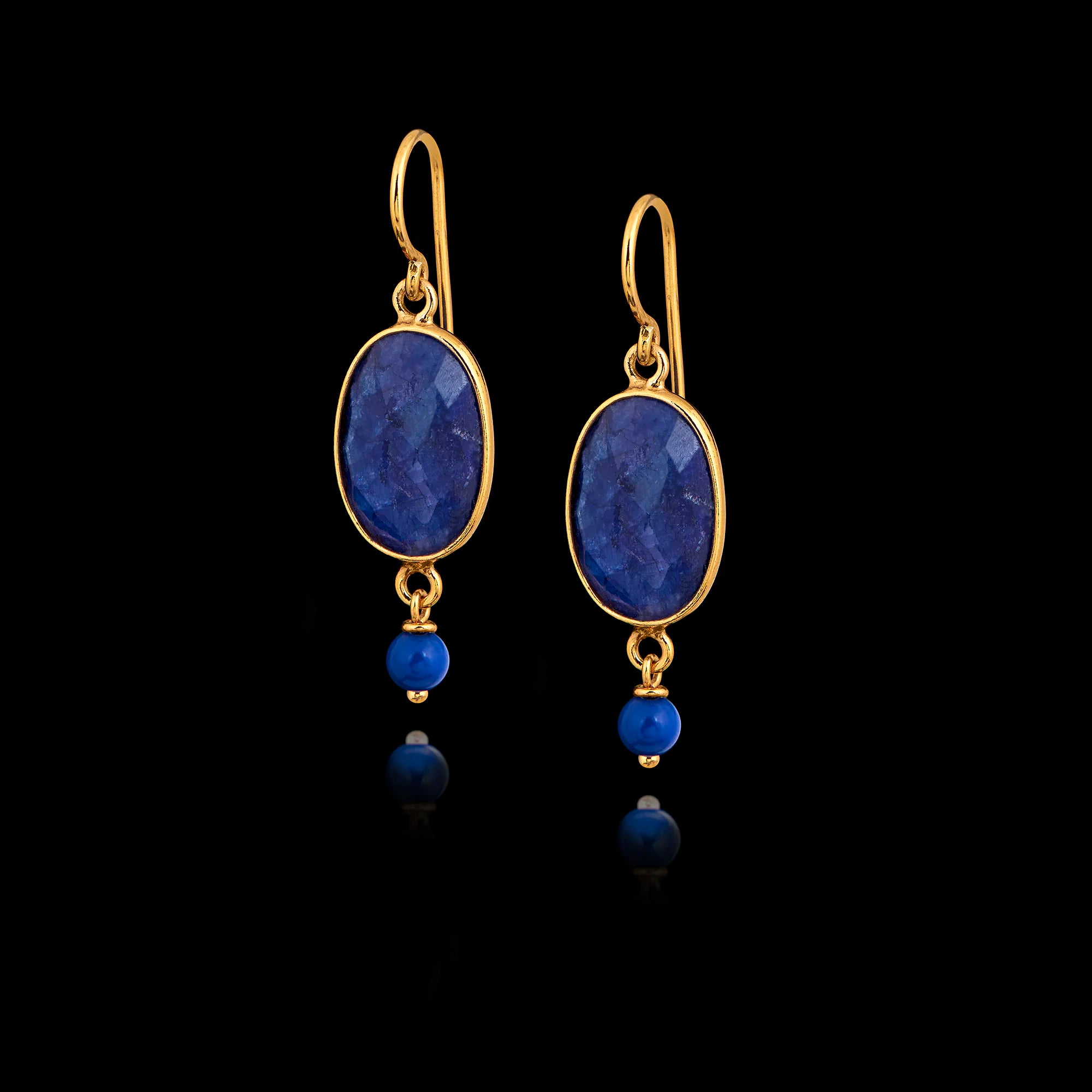 Long gold hook earrings featuring large oval lapis stones and smaller round lapis beads suspended below in gold settings.