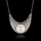 Unique 925 sterling silver statement necklace featuring a round ceramic Vitruvian Man by Da Vinci, set in a textured hammered silver crescent frame.