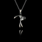 Handcrafted 925 sterling silver swallow pendant with oxidised finish showing the bird with outstretched wings and forked tail in a mid-flight pose, hanging on a silver chain against a black background.