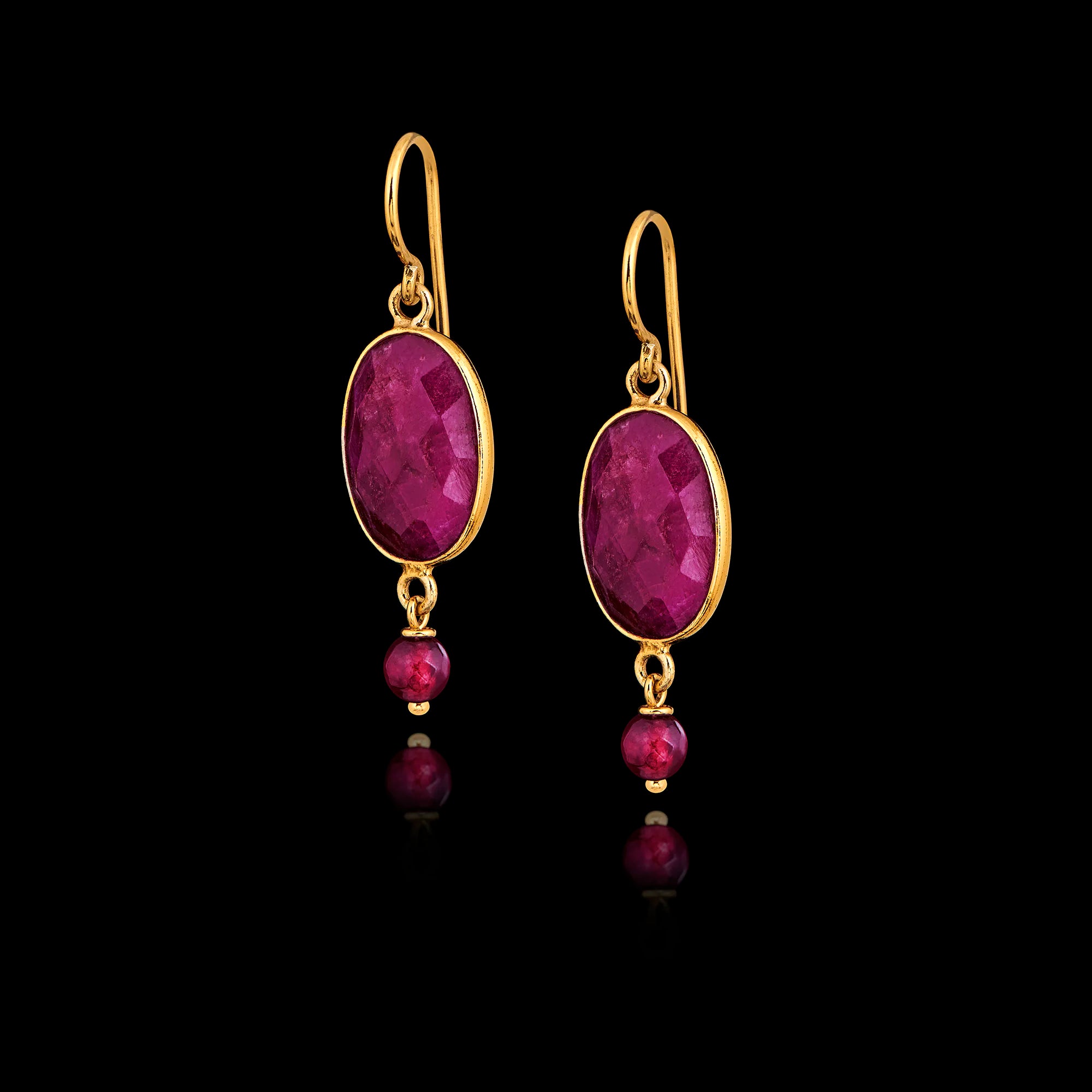 A pair of long gold hook earrings featuring large oval faceted rubies with smaller round ruby beads suspended below in gold settings. Main image