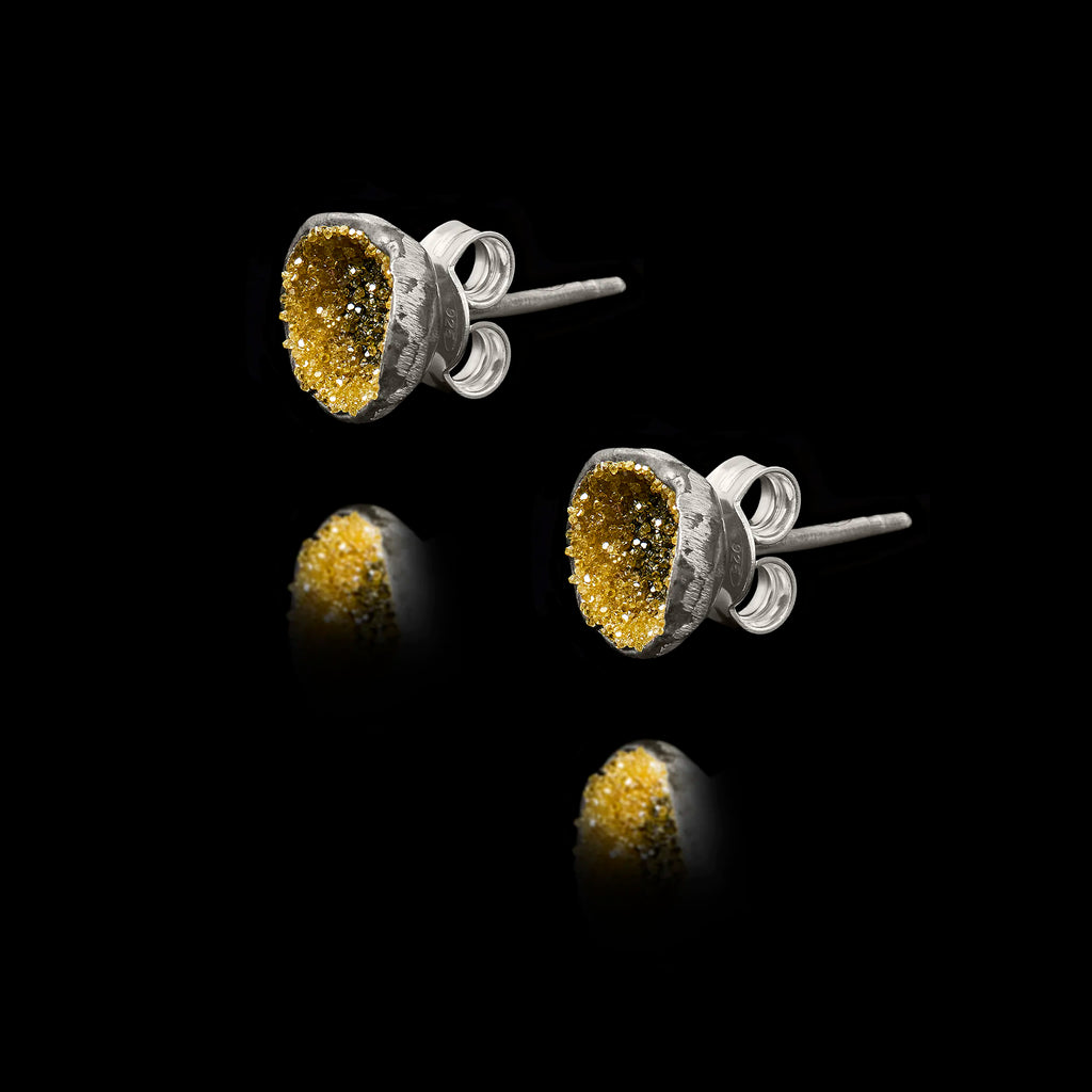 Side view of the diamond dust studs showing the polished silver setting and secure post fastening.