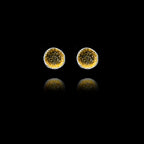 Front view of silver stud earrings featuring a circular inlay of shimmering diamond dust.