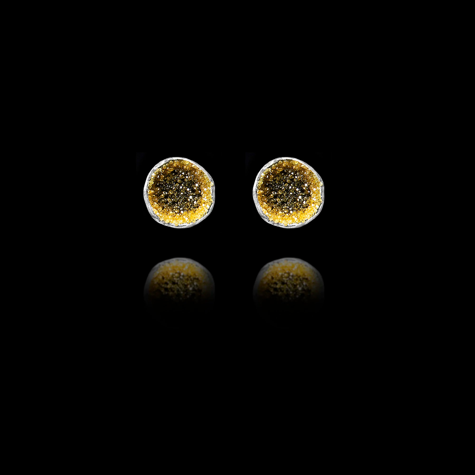 Front view of silver stud earrings featuring a circular inlay of shimmering diamond dust.