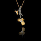 Side angle view of a 925 sterling silver flower branch pendant showing the textured oxidised branch and gold-plated floral blooms with freshwater pearl centres on a gold chain against a black background.
